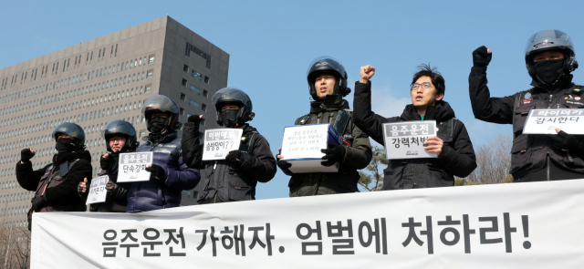 13일 오전 서초구 서울중앙지방검찰청 앞 삼거리에서 열린 배달라이더 및 시민 1,500명 음주운전 가해자 엄벌 촉구 탄원서 접수 기자회견에서 라이더유니온 회원들이 구호를 외치고 있다. 연합뉴스