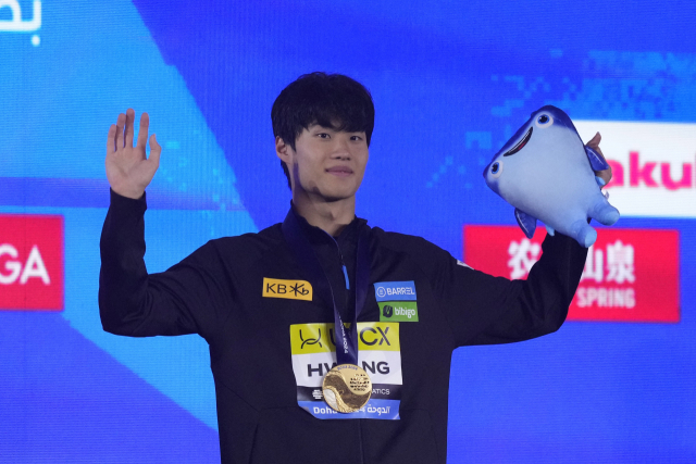 황선우가 14일 남자 자유형 200m 시상식에서 금메달을 목에 걸고 기뻐하고 있다. AP연합뉴스