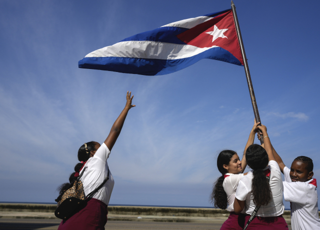 지난달 8일(현지 시간) 쿠바의 수도 아바나에서 학생들이 피델 카스트로의 혁명군 수도 입성 65주년을 기념해 쿠바 국기를 들어보이고 있다. AP연합뉴스