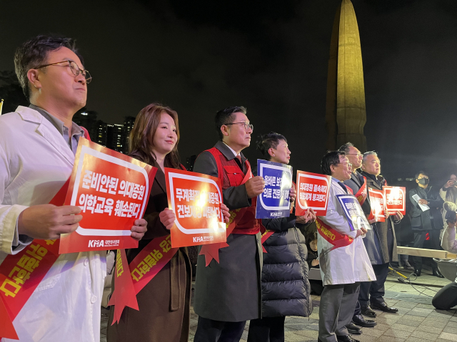 15일 서울 용산구 대통령실 앞에서 열린 '의대 정원 증원·필수의료패키지 저지를 위한 궐기대회'에서 서울시의사회 의사들이 표어를 들고 있다. 신서희 기자