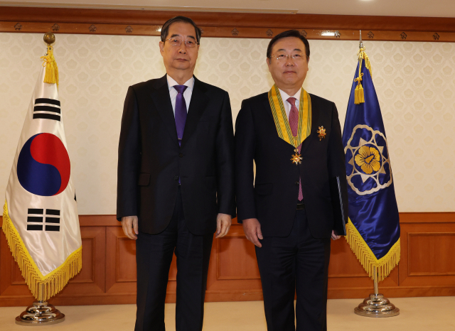 한덕수(왼쪽) 국무총리가 15일 정부서울청사에서 열린 규제 개혁 유공 정부 포상 수여식에서 김종석 규제개혁위원회 민간위원장에게 국민훈장 모란장을 수여한 뒤 기념사진을 촬영하고 있다. 연합뉴스