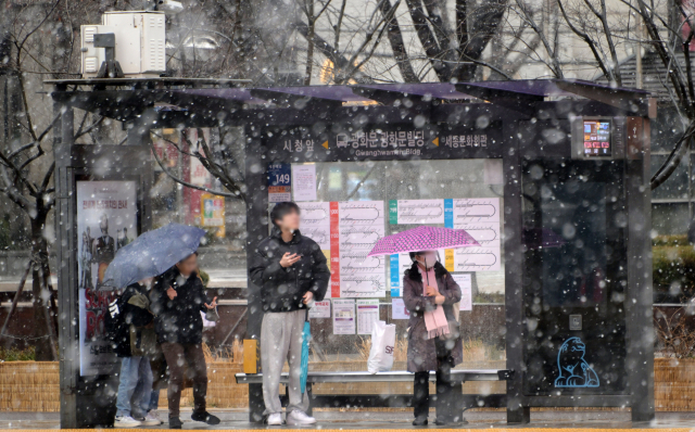 전날에 비해 기온이 급강하하며 눈이 내린 15일 서울 광화문사거리 인근 버스정류장에서 시민들이 버스를 기다리고 있다