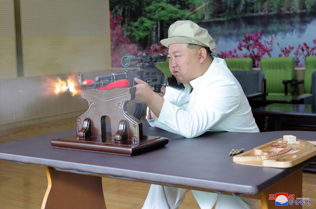 김정은 북한 국무위원장이 지난해 5월 3일 현지 군수공장을 시찰한 자리에서 소총을 시험사격하고 있다. 조선중앙통신·연합뉴스