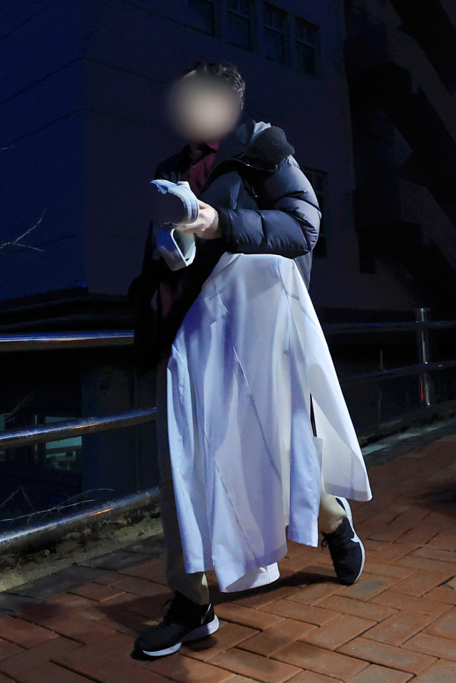 20일 서울 시내 한 대학병원에서 의료진이 가운을 손에 들고 퇴근하고 있다. 연합뉴스