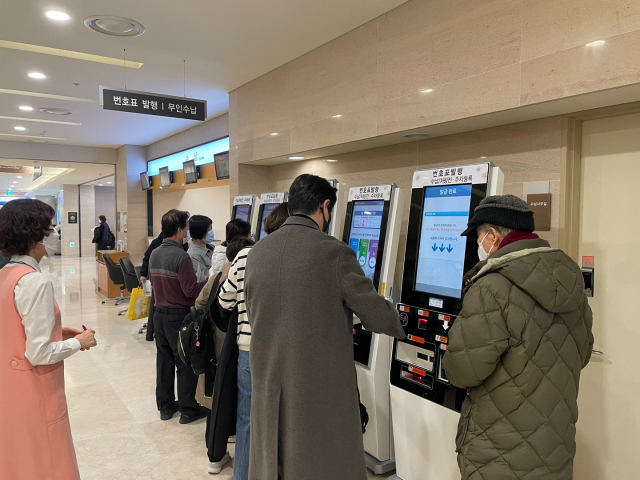 20일 오전 서울 서초구 서울성모병원을 찾은 환자들이 진료를 받기 위해 번호표를 뽑고 있다=이정훈 기자