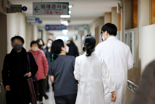 전공의 집단이탈이 시작된지 이틀째인 21일 광주 동구 조선대병원에서 의료진들이 복도를 지나고 있다. 연합뉴스