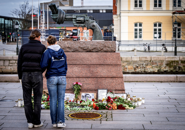 20일(현지시간) 스웨덴 말모의 안나 린드 플레이스에 있는 칼 프레드리크 로이터워드의 조각상 '비폭력' 앞에 알렉세이 나발니의 초상화와 함께 그를 추모하는 꽃, 조명 등이 놓여 있다. 로이터연합뉴스