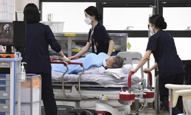 정부가 군 병원 12곳 응급실을 민간인에게 개방한 지난 20일 오후 의료진들이 경기 성남시 국군수도병원 응급실로 민간인 환자를 옮기고 있다. 연합뉴스