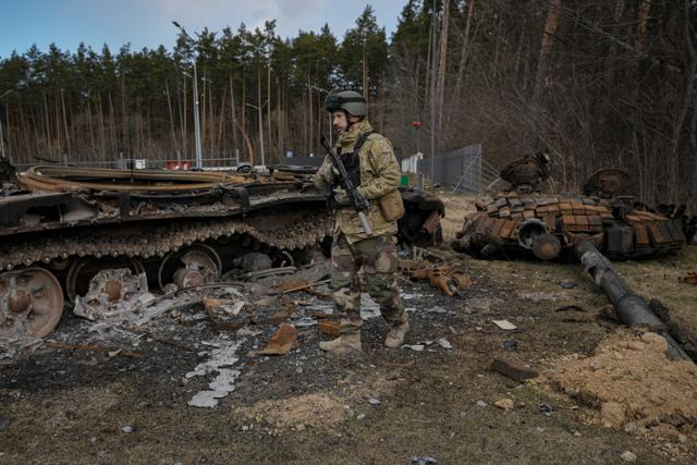 우크라이나 스토얀카에서 우크라이나군 병사가 파괴된 러시아 전차를 살펴보고 있다. AP연합뉴스