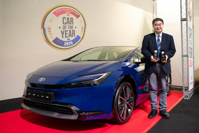 콘야마 마나부 토요타코리아 사장이 21일 자동차전문기자협회가 진행한 ‘2024 대한민국 올해의 차’ 시상식에서 올해의 디자인, 올해의 하이브리드 크로스오버를 수상한 5세대 프리우스와 기념 촬영을 하고 있다. 사진 제공=토요타코리아