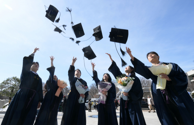 23일 서울 종로구 성균관대학교에서 열린 2024년 겨울 전체 학위수여식에서 졸업생들이 학사모를 던지고 있다.