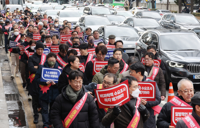 전공의들의 집단행동 엿새째인 25일 김택우 대한의사협회 비상대책위원장을 비롯한 의사들이 서울 용산구 대한의사협회 회관에서 열린 '의대정원 증원 저지를 위한 전국의사대표자 확대회의'를 마친 뒤 용산 대통령실을 향해 가두 행진을 하고 있다. 오승현 기자