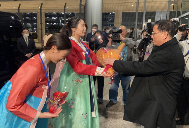 한복을 입은 재일본조선인총연합회(조총련) 여성들이 25일 도쿄 하네다공항에 도착한 북한 여자축구 대표팀 관계자에게 꽃다발을 전달하고 있다./연합뉴스