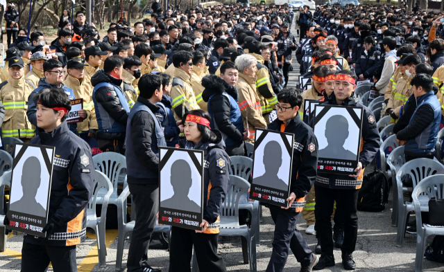 26일 서울 여의도 국회의사당 인근에서 열린 ‘7만 소방관 총궐기대회’에서 소방공무원들이 근무 중 순직한 소방관들의 상징하는 영정을 들고 입장하고 있다. 이날 집회에는 소방관과 가족 등 1000여 명이 참가했으며 이들은 정부에 인력 증원과 온전한 국가직 전환 등을 촉구했다. 권욱 기자