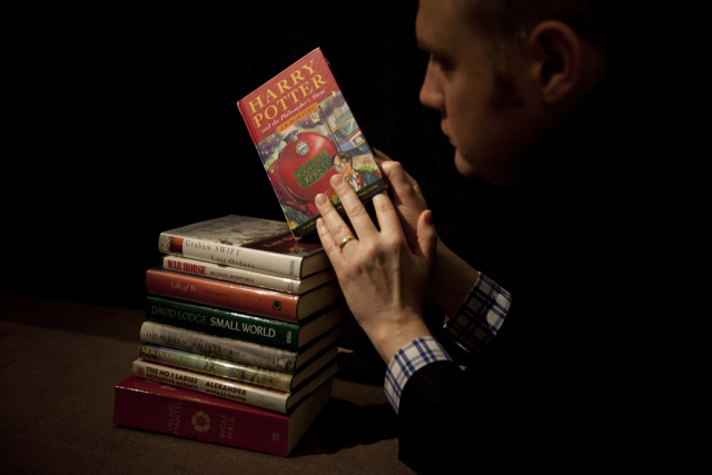 소더비 경매장의 한 직원이 지난 2013년 5월 소설 해리포터 시리즈 1권인 ‘해리 포터와 마법사의 돌’ 초간본을 들고 있다. AP연합뉴스
