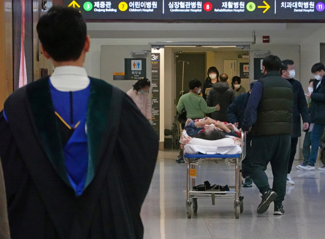 정부와 의료계가 강대강 대치를 이어가며 악화일로를 걷고 있는 26일 서울의 한 대형병원에서 의대 졸업생과 환자가 오가고 있다.