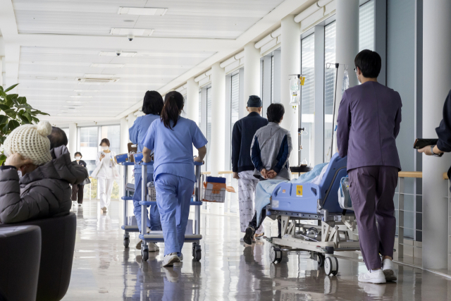 전공의의 집단 이탈이 일주일 이상 이어지는 가운데 27일 서울의 한 대학병원에서 간호사들이 환자들을 옮기고 있다. 연합뉴스