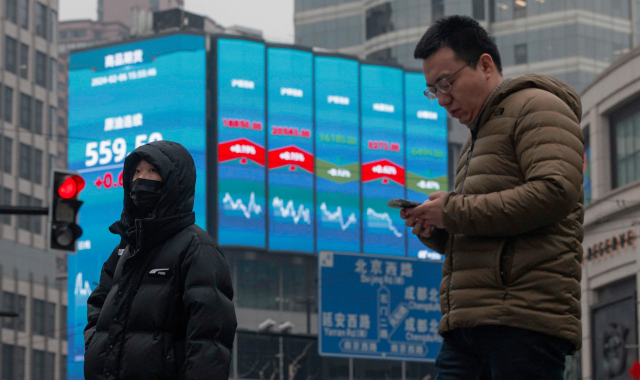 중국 상하이의 대형 증시 전광판 앞을 시민들이 지나고 있다./EPA연합뉴스