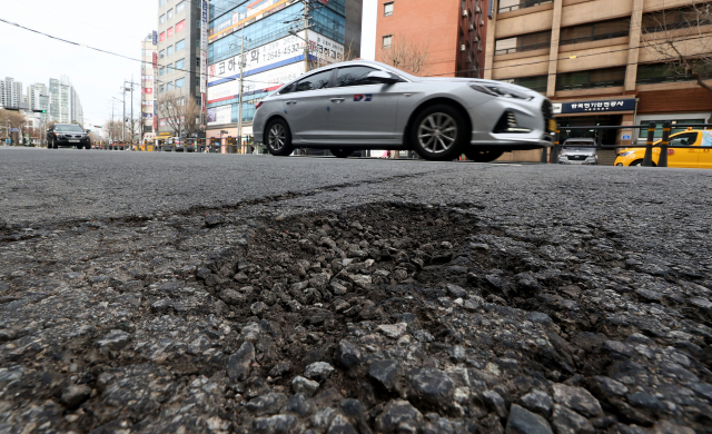 따뜻한 날씨가 이어지며 전국 도로 곳곳에 포트홀이 발생 중인 가운데 27일 오후 서울 마포구의 한 도로에 포트홀이 생겨나 있다. 연합뉴스