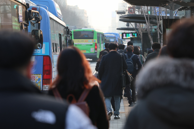 13일 오전 출근길에 오른 시민들이 서울 광화문 네거리 버스정류장에 내려 일터로 향하고 있다. 연합뉴스