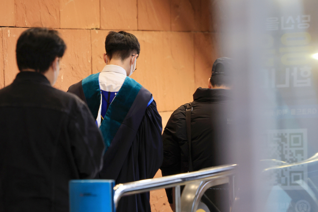 서울 시내 한 의과대학에서 한 졸업생이 학위수여식을 마친 뒤 이동하고 있다. 연합뉴스