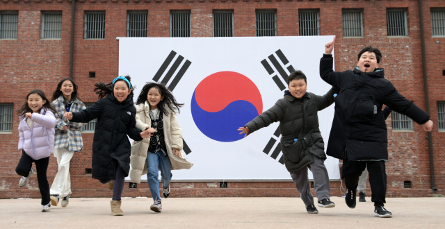 3.1절을 하루 앞둔 29일 서울 서대문구 서대문형무소역사관 대형태극기 앞에서 어린이들이 밝은 표정을 지으며 뛰고 있다.