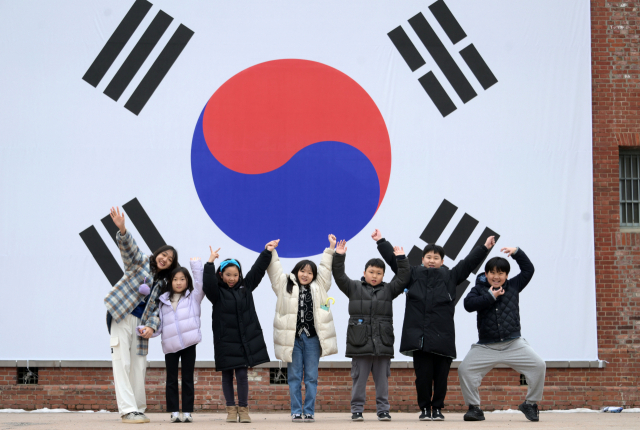 3.1절을 하루 앞둔 29일 서울 서대문구 서대문형무소역사관 대형태극기 앞에서 어린이들이 밝은 표정을 지으며 만세를 외치고 있다.