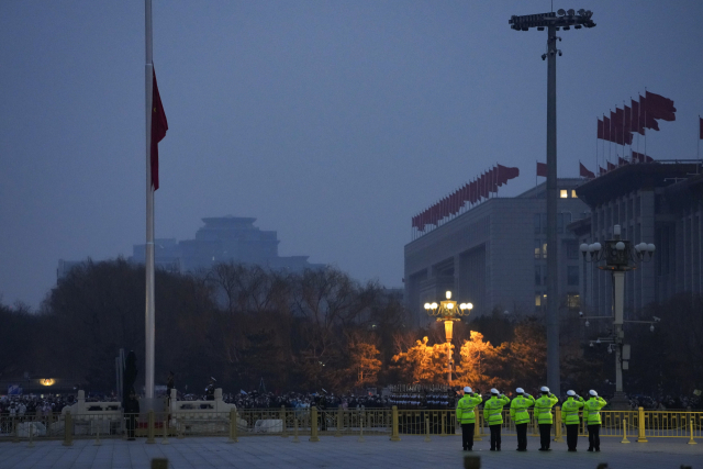 5일 중국 베이징 인민대회당 앞 국기 게양대에서 경찰관들이 경례를 하고 있다. AP연합뉴스
