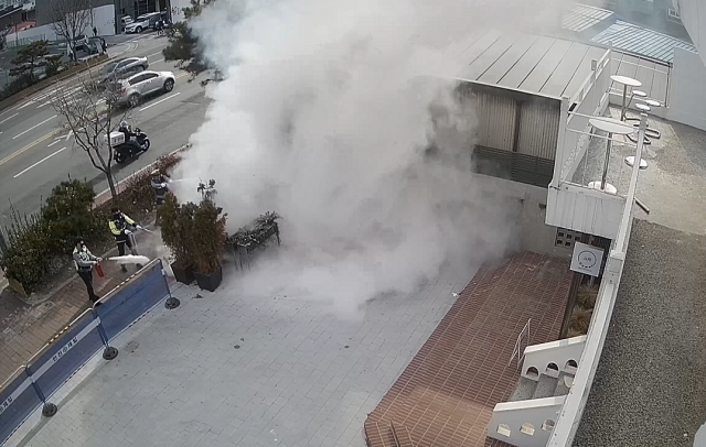 3일 서울 강북구 미아동의 한 카페에 심어진 조경수에서 화재가 발생하자 인근에서 교통 단속 중이던 경찰관 5명이 이를 진압하고 있는 CCTV 영상 장면.