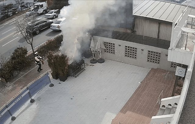 3일 서울 강북구 미아동의 한 카페에 심어진 조경수에서 화재가 발생하자 인근에서 교통 단속 중이던 경찰관 5명이 이를 진압하고 있는 CCTV 영상 장면.
