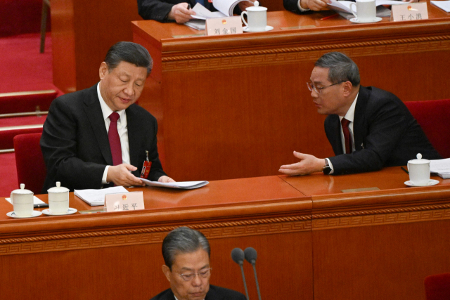 시진핑(왼쪽) 중국 국가주석이 5일 베이징 인민대회당에서 열린 전국인민대표대회 개막식에서 리창(오른쪽) 중국 국무원 총리와 대화하고 있다. AFP연합
