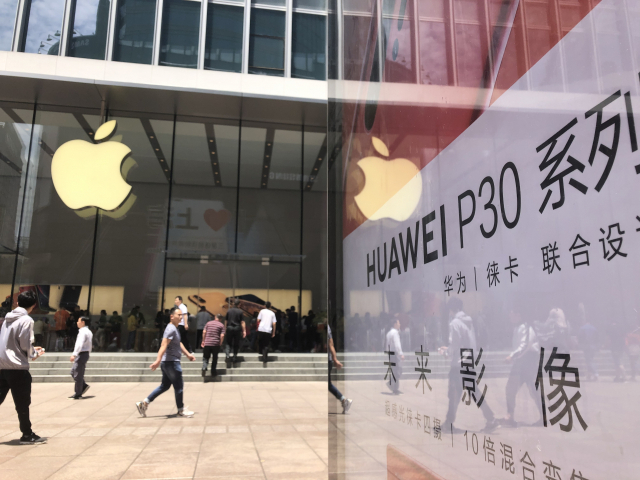 중국 상하이 난징둥루에 있는 애플 스토어 앞에 화웨이의 스마트폰 광고판이 걸려 있다. 연합뉴스