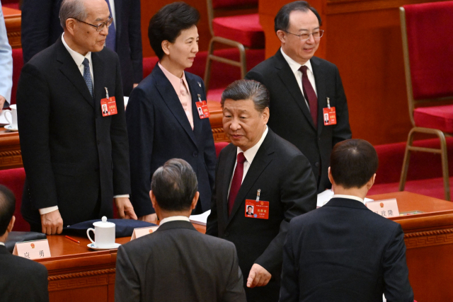 시진핑(가운데) 중국 국가주석이 5일 베이징 인민대회당에서 열린 전국인민대표대회 개막식이 끝난 뒤 왕이(앞줄 왼쪽) 외교부장과 담소를 나누고 있다. AFP연합뉴스