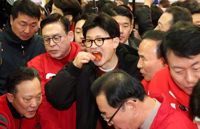 국민의힘 한동훈 비상대책위원장이 5일 오전 청주 육거리시장을 방문, 떡볶이를 시식하고 있다. 연합뉴스