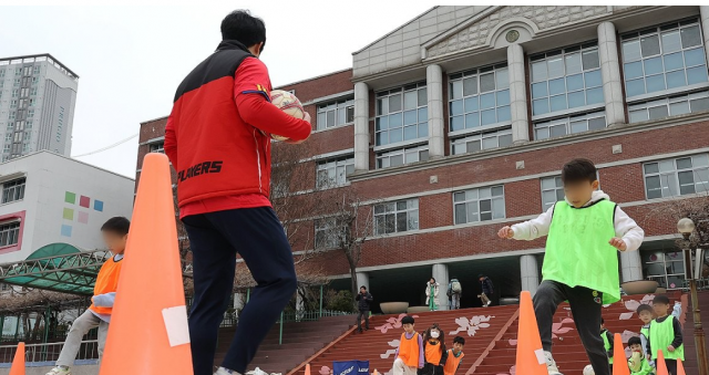 지난 5일 오후 서울 아현초등학교 '늘봄학교' 프로그램 중 축구에 참여한 학생들이 선생님과 다양한 기술을 체험하고 있다. 연합뉴스