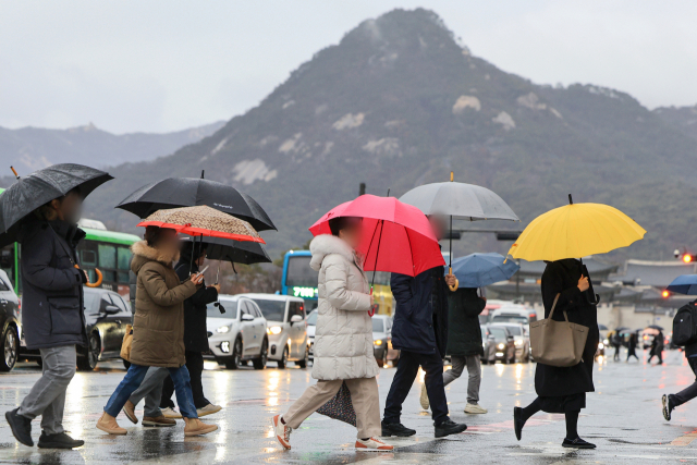서울 광화문네거리에서 우산을 쓴 시민들이 횡단보도를 건너고 있다. 연합뉴스