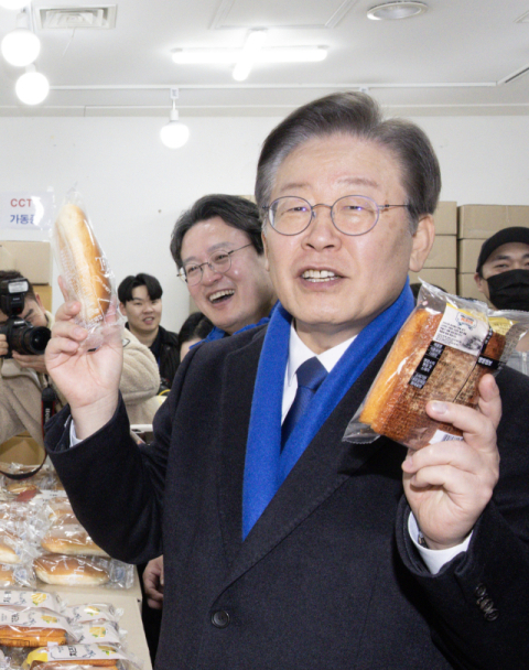 이재명 더불어민주당 대표가 지난 5일 오후 서울 영등포구 뉴타운 지하쇼핑몰을 찾아 양손에 빵을 들어 보이고 있다. 연합뉴스