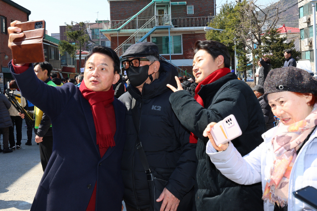 원희룡(왼쪽) 전 국토교통부 장관이 10일 인천 계양구 계산동성당 척사 대회에서 한 시민의 휴대폰으로 사진을 찍어주고 있다. 연합뉴스