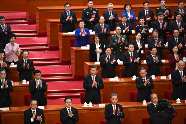 시진핑(둘째 줄 가운데) 중국 국가주석이 11일 베이징 인민대회당에서 열린 제14차 전국인민대표대회 폐막 회의에서 참석자들과 함께 박수를 치고 있다. AFP연합뉴스