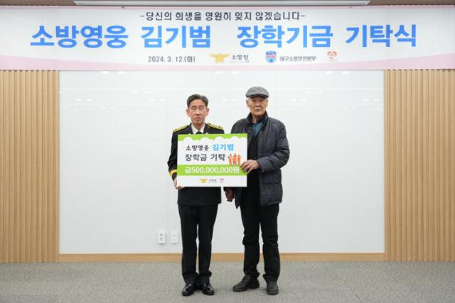 고 김기범 소방관의 부친 김경수(오른쪽) 씨가 12일 대구 강북소방서에서 열린 '소방영웅 김기범 장학금 기탁식' 행사에서 김조일 소방청 차장과 기념 촬영을 하고 있다. 사진 제공=소방청