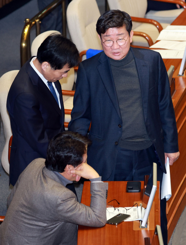 전해철(오른쪽) 더불어민주당 의원, 김민기 의원과 안민석 의원이 지난달 29일 국회에서 열린 본회의에서 대화하고 있다. 연합뉴스