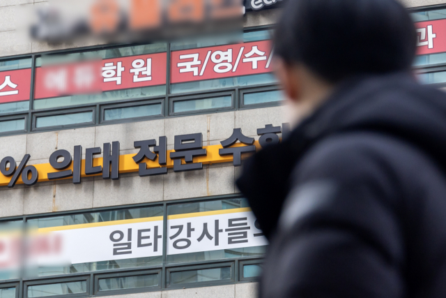 한 학생이 지난달 8일 서울 목동 학원가에 부착된 의대 입시 홍보 현수막을 보고 있다. 연합뉴스