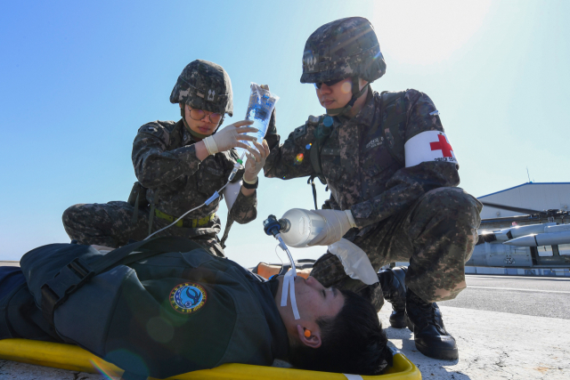 13일 자유의 방패(FS) 연습 일환으로 진행된 전시 한미 연합 의무지원훈련에서 해군 해상기동헬기(UH-60)로 이동한 해군 2함대 군 의료진이 덕적도에서 발생한 외상환자를 응급조치 하고 있다. 사진 제공=해군