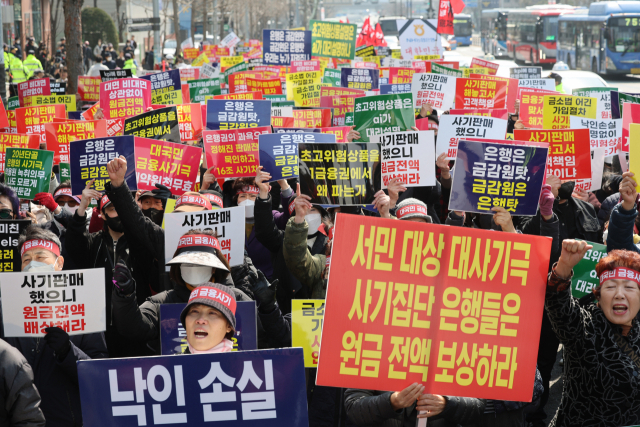 15일 서울 중구 NH농협은행 앞에서 열린 ‘대국민 금융 사기 규탄 집회’에서 홍콩H지수 주가연계증권(ELS) 피해자 모임 관계자들이 원금 전액 배상을 촉구하고 있다. 연합뉴스