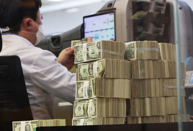 1월 4일 서울 명동 하나은행 본점에서 한 직원이 미국 달러를 살펴보고 있다. 연합뉴스