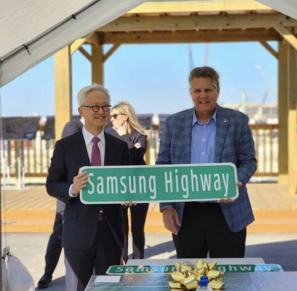 경계현(왼쪽) 삼성전자 사장이 미국 테일러시 파운드리 공장 건설 현장에서 빌 그라벨 윌리엄슨카운티장에게 ‘삼성 고속도로’ 표지판을 전달 받고 있다. 페이스북