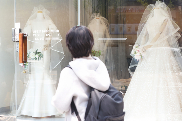 한 시민이 진열장에 전시된 웨딩 드레스를 살펴보고 있다. 연합뉴스
