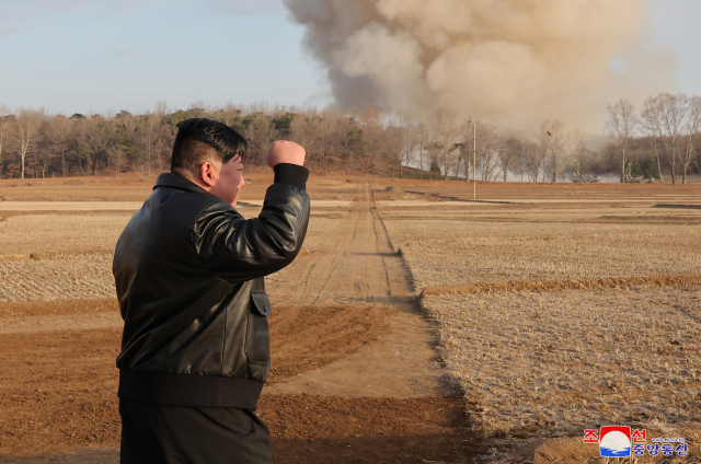 김정은 북한 국무위원장이 18일 서부지구 포병부대 초대형방사포 사격훈련을 지켜보며 주먹을 불끈 쥐고 있다. 연합뉴스