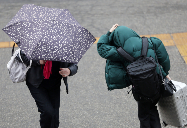 서울역 앞에서 한 시민이 우산을 쓴 채 길을 걷고 있다. 연합뉴스