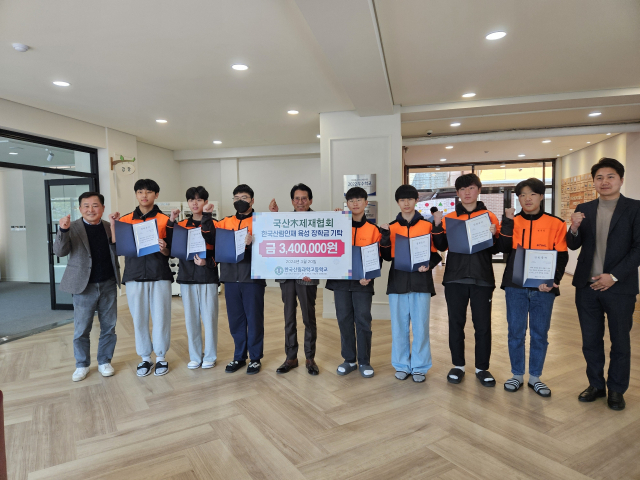 한국국산목제재협회 신용구(왼쪽에서 다섯번째) 회장이 7명의 한국산림과학고등학교 신입생 장학생에게 장학금을 수여한 뒤 기념촬영을 하고 있다. 사진제공=한국국산목제재협회